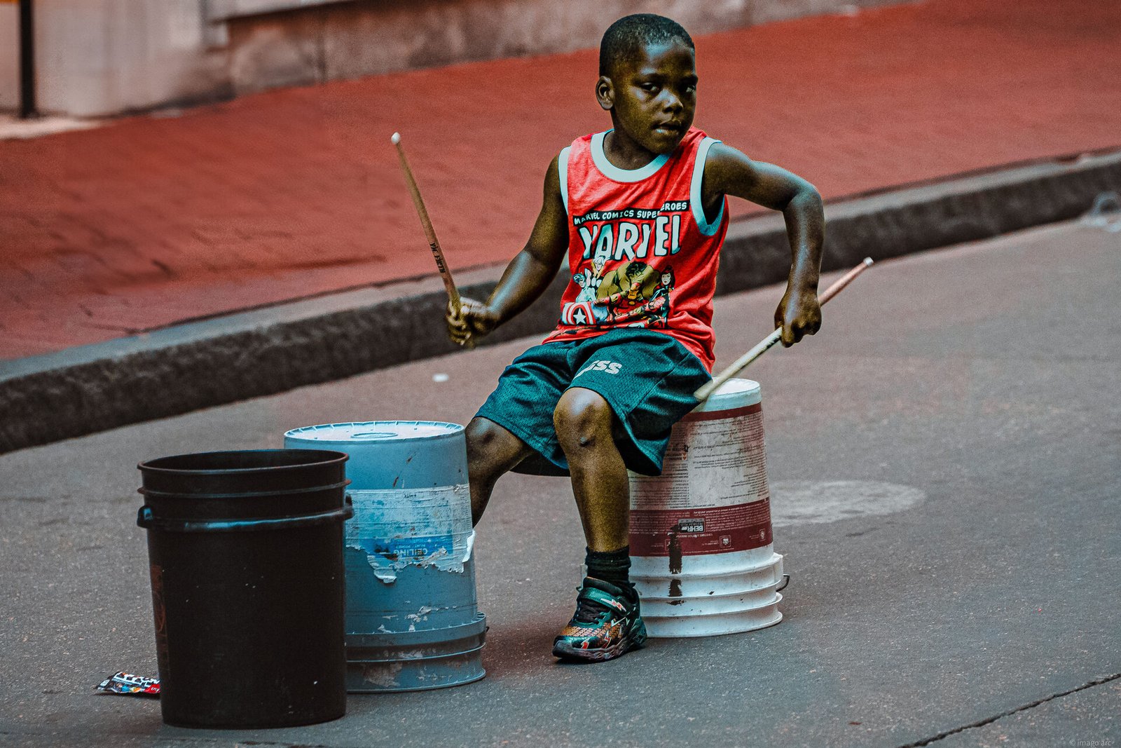 Young boy playing bucket drums on the street, New Orleans, Louisiana