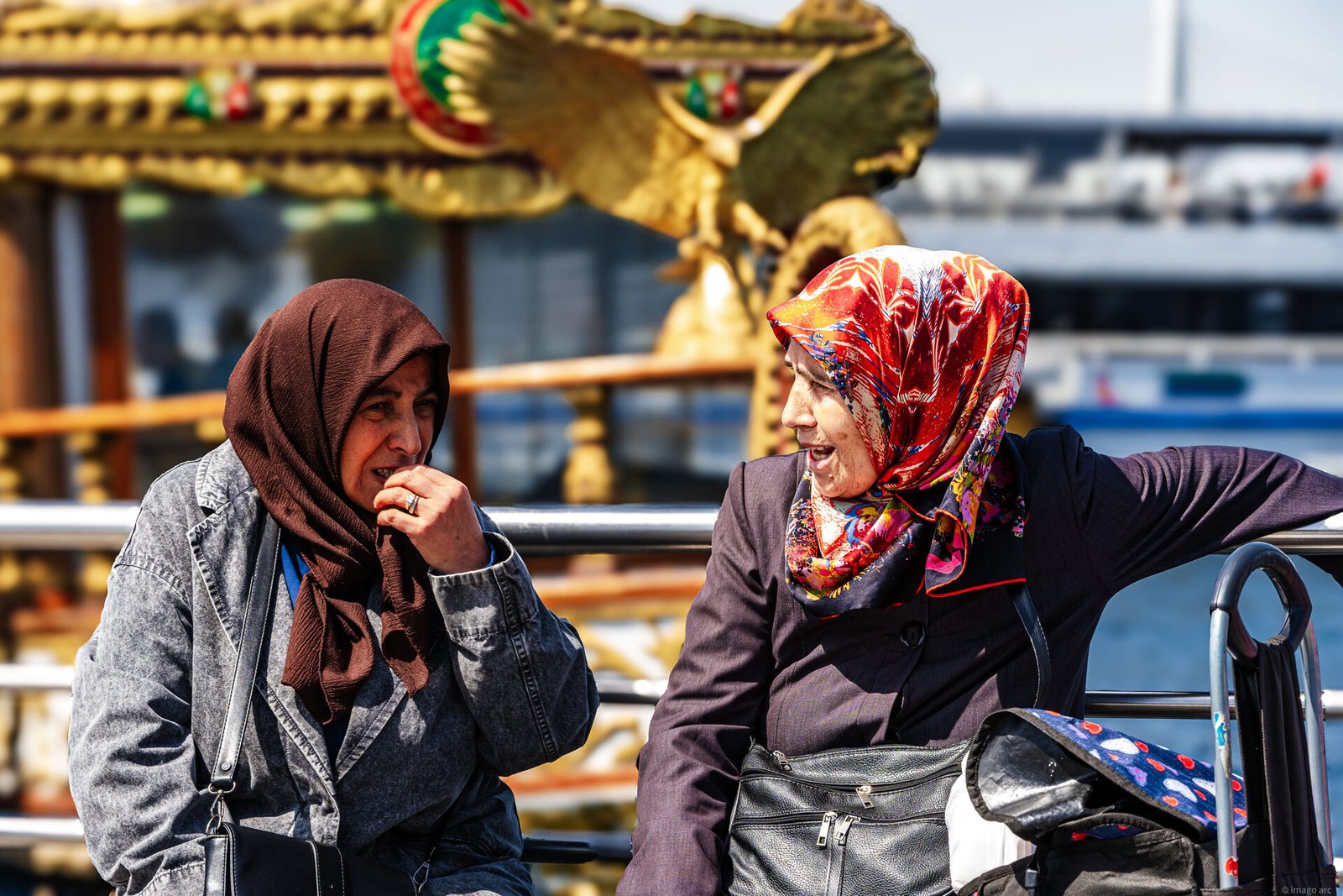 Two women in headscarves sharing a conversation on a Bosphorus ferry, Istanbul, Turkey