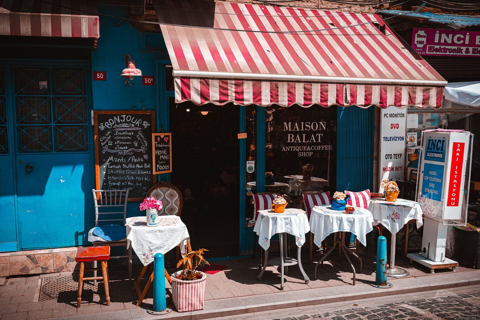 Colorful street cafe with striped awning and outdoor tables in the Balat neighborhood, Istanbul, Turkey
